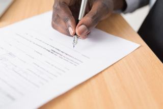 Ce que le salarié signe dans une rupture conventionnelle Convention de rupture posée sur un bureau à côté d'un Code du travail